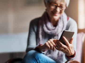 Lady smiling holding a smartphone in her hand