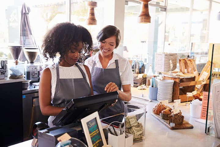 Two women working behind the counter in a coffee shop