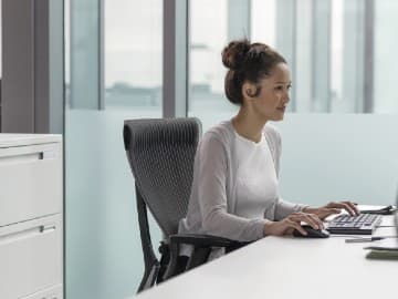 woman at a desk working on a computer in an office setting